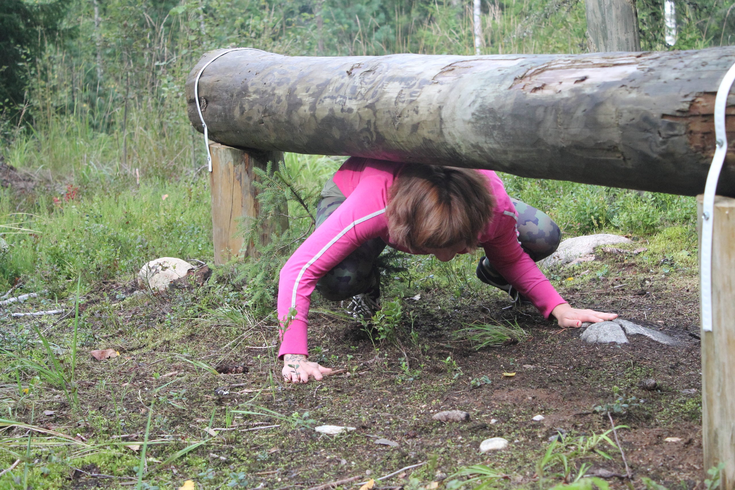 Metsäkuntosalilla on armeijatyyppinen rata, jossa pääsee kokeilemaan taitojaan. Kuvassa Anu menee puomien alitse.