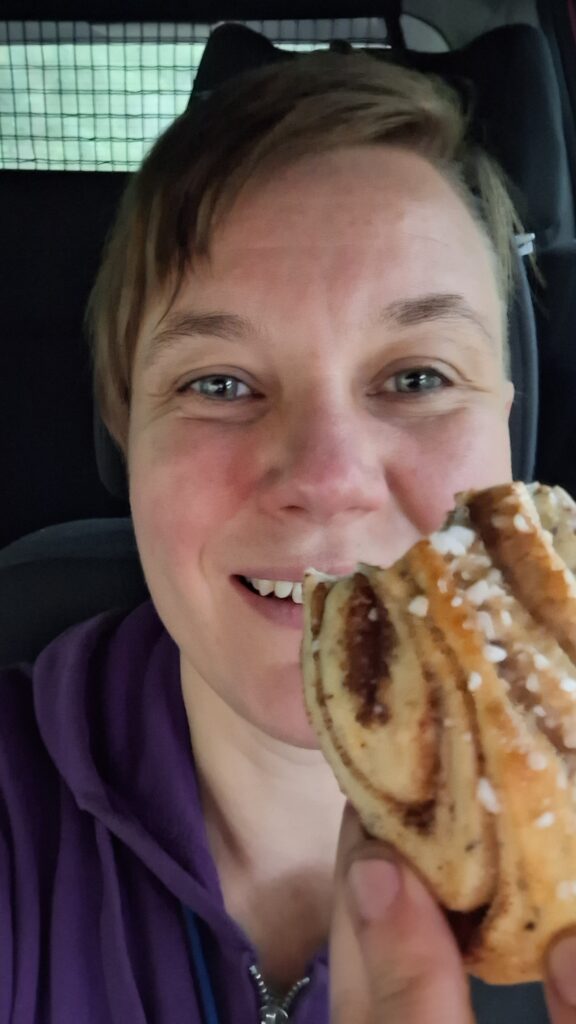 Anu ja Korvapuusti, josta on haukattu pala. Lammaskahvila